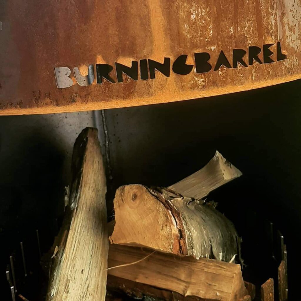Brandhout gestapeld in een Burning Barrel, met het lasergesneden naamplaatje